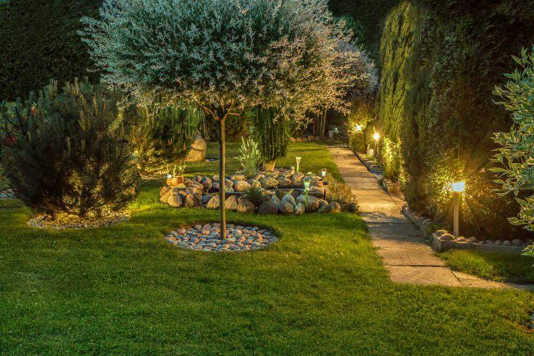Private garden in the evening, illuminated by lamps